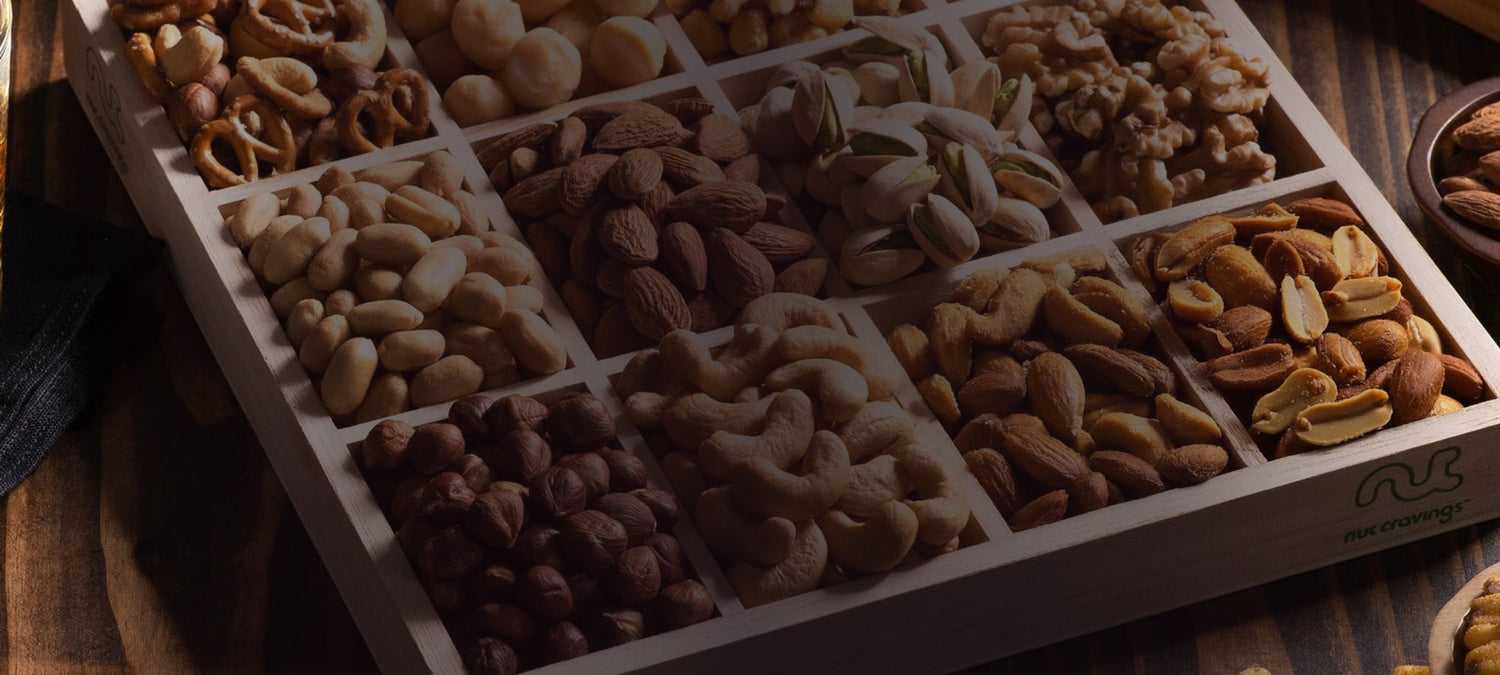 Nut Cravings mixed nut gift tray styled on a dark wood table